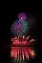 Rich and colorful fireworks over surface of Brno`s Dam with reflection on the surface of lake Royalty Free Stock Photo