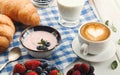 Continental breakfast with croissants and berries on checkered c