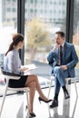 Rich entrepreneur enjoying talk with young experienced journalist