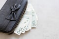 Rich girl or woman in Poland. Black purse full of polish money on grey marble table Royalty Free Stock Photo