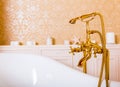 Rich gold faucet and white bath in the bathroom Royalty Free Stock Photo