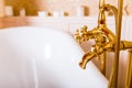 Rich gold faucet and white bath in the bathroom Royalty Free Stock Photo