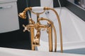 Rich gold plumbing on white bath in the bathroom Royalty Free Stock Photo