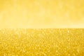 Rich golden sparkle glow bokeh texture as background with surface and wall.