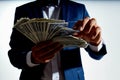 rich guy with a bundle of big money and in a classic suit on a light background Royalty Free Stock Photo