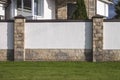 Rich house, white wall, horizontal rectangular stones and a green lawn