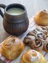 Rich lush buns lie on a towel. Fresh milk is poured into the clay mug Royalty Free Stock Photo