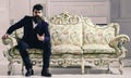 Rich man. Fashion and style concept. Man with beard and mustache wearing fashionable classic suit, sits on old fashioned