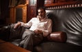 Rich man sitting on vintage leather sofa