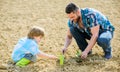 Rich natural soil. Eco farm. new life. soils and fertilizers. small boy child help father in farming. father and son