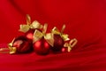 Rich red christmas background - heap different shimmer balls with golden ribbon on saturated smooth silky wavy backdrop.