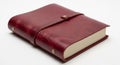 Rich Red Leather Bound Journal with Strap and Brass Studs on White Surface notebook diary Royalty Free Stock Photo