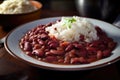 Rich and savory close-up of red beans and rice with steam rising from the plate and colorful spices on top