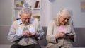 Rich senior woman counting dollars, poor old man holding coins in hand, society Royalty Free Stock Photo