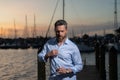 Rich stylish business man dreaming and thinking near the yacht. Portrait of confident man in yacht club. Stylish