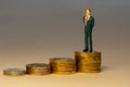 Rich successful business man standing on top of increasing piles of gold coins. Business career concept Royalty Free Stock Photo