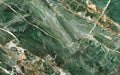 A rich tapestry of verdant green marble, interwoven with natural gold fissures, presents a lush and affluent aesthetic