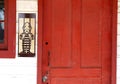 Mr. Monopoly Man shown wearing a jail uniform by a locked red door. Royalty Free Stock Photo