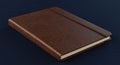 Richly Textured Brown Leather Journal with Elastic Strap on a Deep Navy Background Royalty Free Stock Photo