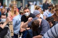 A caucasian protester wears a PPE Face Mask while silently kneeling at a Black Lives Matter Protest and surrounded by other