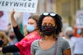 A powerful black female leader wears a Black Lives Matter PPE face mask at a BLM protest in Richmond, North Yorkshire