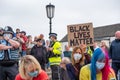 A woman peacefully holds a Black Lives Matter placard while kneeling in a crowd at a protest in Richmond, North Yorkshire
