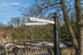 An old fashioned street sign next to the River Swale pointing towards the Market Place and the Station in Richmond, North