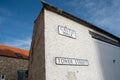 Old fashioned street signs on a white building with a blue sky in the background in Richmond, North Yorkshire