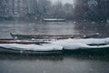 Boats covered in snow and moored on the river in West part of the city