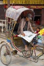 Rickshaw driver reading newspaper in Kathmandu