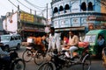 Rickshaw drives through the crowded street with many bikes in Lucknow, India