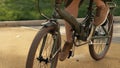 Ridding bicycle wheels. Close up young woman bicycle riding at road park