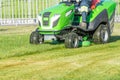 Ride lawn mower mows a green fresh grass