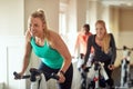 Ride to the rhythm of fitness. a young woman working out with an exercise bike in a spinning class at the gym. Royalty Free Stock Photo