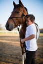 Rider boy caressing a horse in the ranch Royalty Free Stock Photo