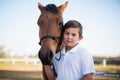 Rider boy caressing a horse in the ranch Royalty Free Stock Photo