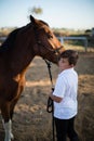 Rider boy caressing a horse in the ranch Royalty Free Stock Photo