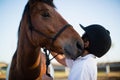 Rider boy caressing a horse in the ranch Royalty Free Stock Photo