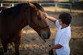 Rider boy caressing a horse in the ranch Royalty Free Stock Photo