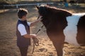 Rider boy caressing a horse in the ranch Royalty Free Stock Photo