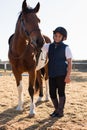 Rider boy caressing a horse in the ranch Royalty Free Stock Photo