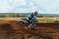 Rider on a cross-country motorcycle in sports equipment turns on a sharp turn at high speed