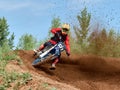 Rider on a cross-country motorcycle in sports equipment turns on a sharp turn at high speed