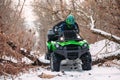 Rider driving in the quadbike race in winter in the forest Royalty Free Stock Photo