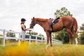 Rider in equestrian clothes holding the reins and leading horse, side view Royalty Free Stock Photo