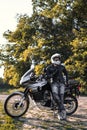 rider guy use smart phone in jeans biker jacket and helmet sit on tourist touring motorcycle. outdoors, dual sport adventure