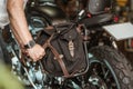 Rider install a motorcycle saddlebag or side bag on luggage bracket vintage motorbike. motorcycle travel concept. selective focus