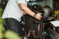 Rider install a motorcycle saddlebag or side bag on luggage bracket vintage motorbike motorcycle travel concept. selective focus