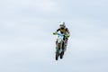 A rider of the Motocross Championship of Ukraine in flight. Motocross rider jumps in the blue sky with clouds