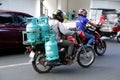 RIder use motorcycle to deliver multiple tanks of LPG or liquified petroleum gas to a customer Royalty Free Stock Photo